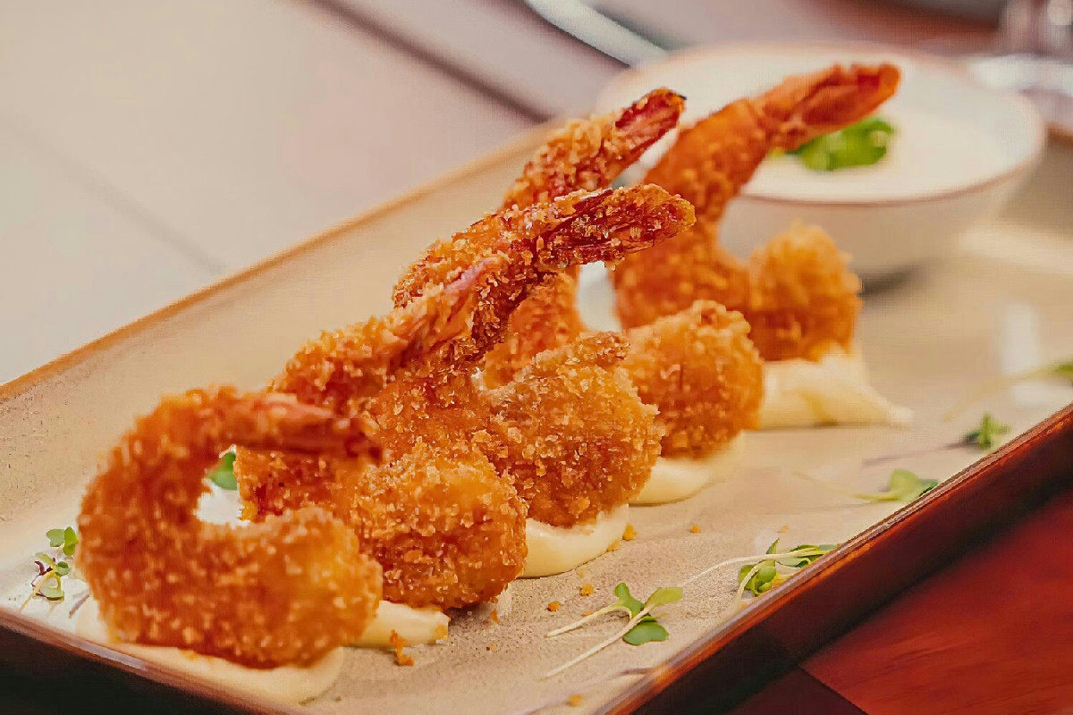 Brodo orientale ricco di sapori croccanti: gamberi in pastella leggera e profumi di mare